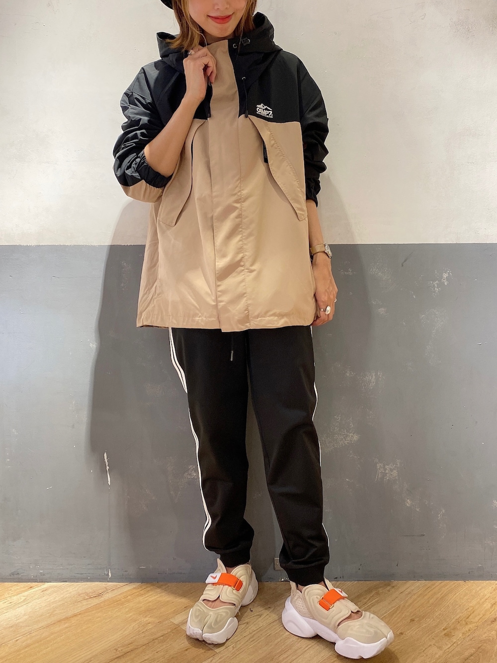 ベージュ系のマウンテンパーカー、ブラック系のその他パンツ、ベージュ系のサンダルを着用したレディースの秋コーディネートの1枚目の写真