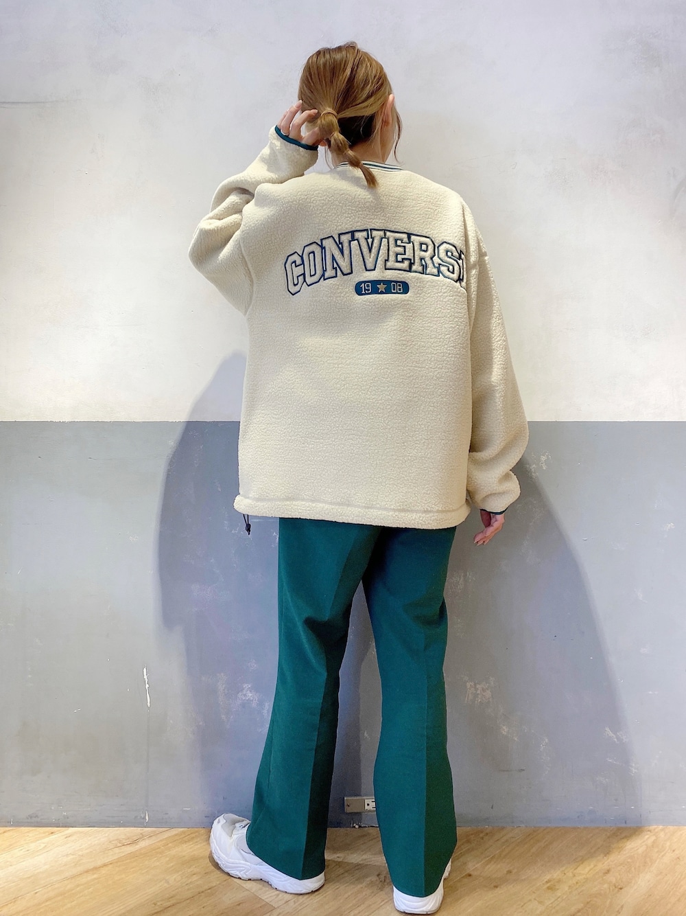 ホワイト系のスウェット、グリーン系のスラックスを着用したレディースの秋コーディネートの1枚目の写真