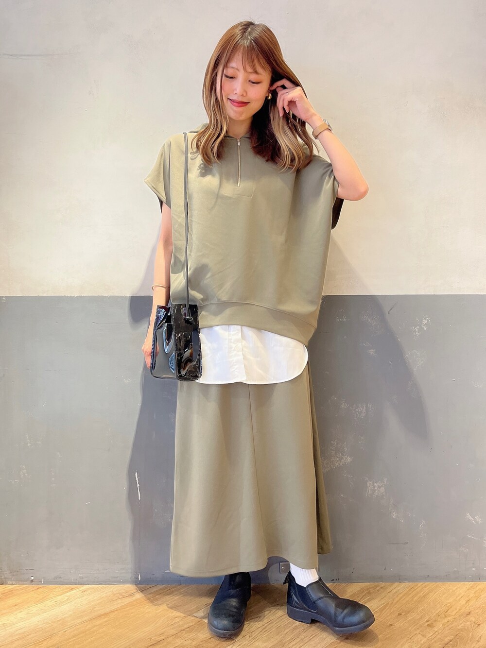 ブラック系のショルダーバッグ、ブラウン系のその他トップス、ブラウン系のスカートを着用したレディースの春コーディネートの1枚目の写真