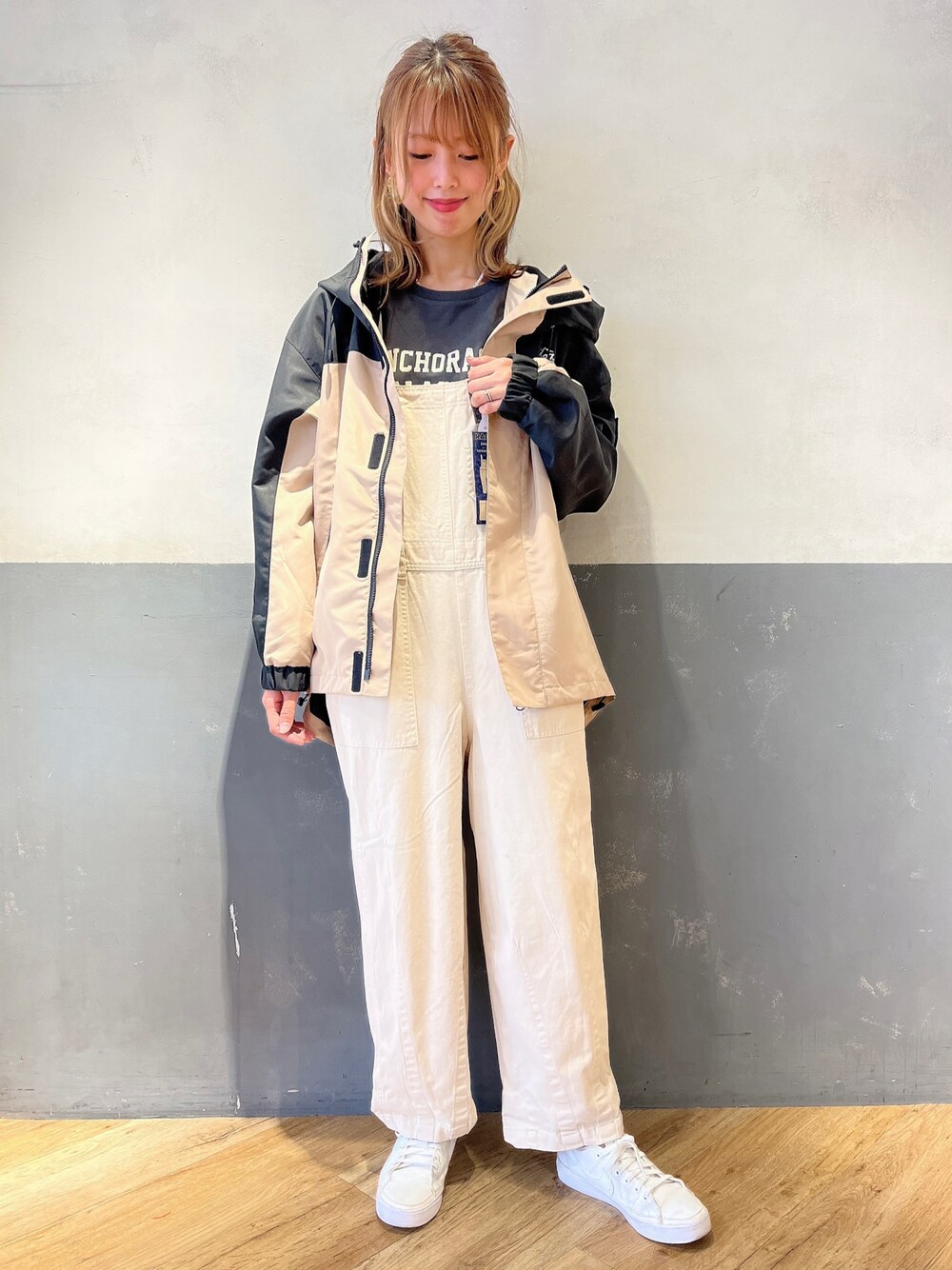 ホワイト系のサロペット/オーバーオール、ベージュ系のマウンテンパーカー、ブラック系のTシャツ/カットソーを着用したレディースの冬コーディネートの1枚目の写真