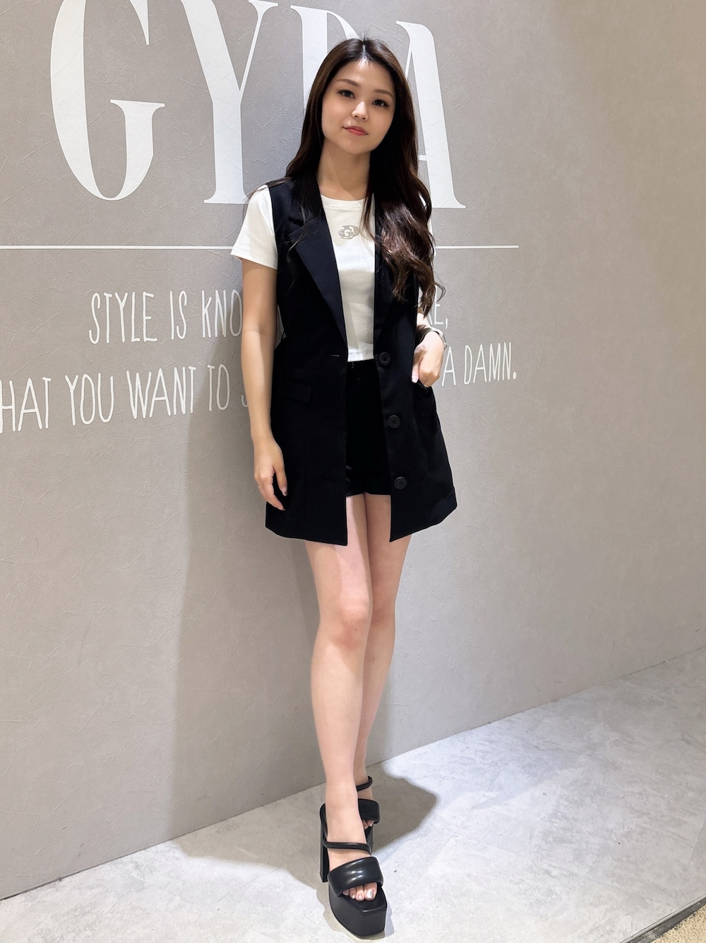 ブラック系のサンダル、ブラック系のベスト、ブラック系のその他パンツを着用したレディースの春コーディネートの1枚目の写真