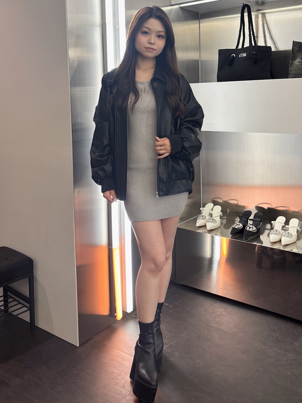 シルバー系のワンピース、ブラック系のブーツ、ブラック系のブルゾンを着用したレディースの春コーディネートの1枚目の写真