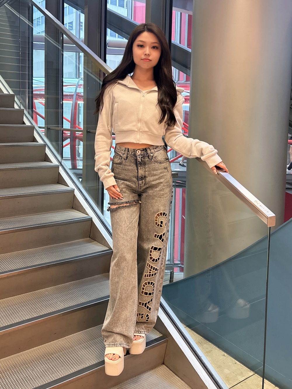 ホワイト系のパーカー、ブルー系のデニムパンツ、ホワイト系のサンダルを着用したレディースの春コーディネートの1枚目の写真