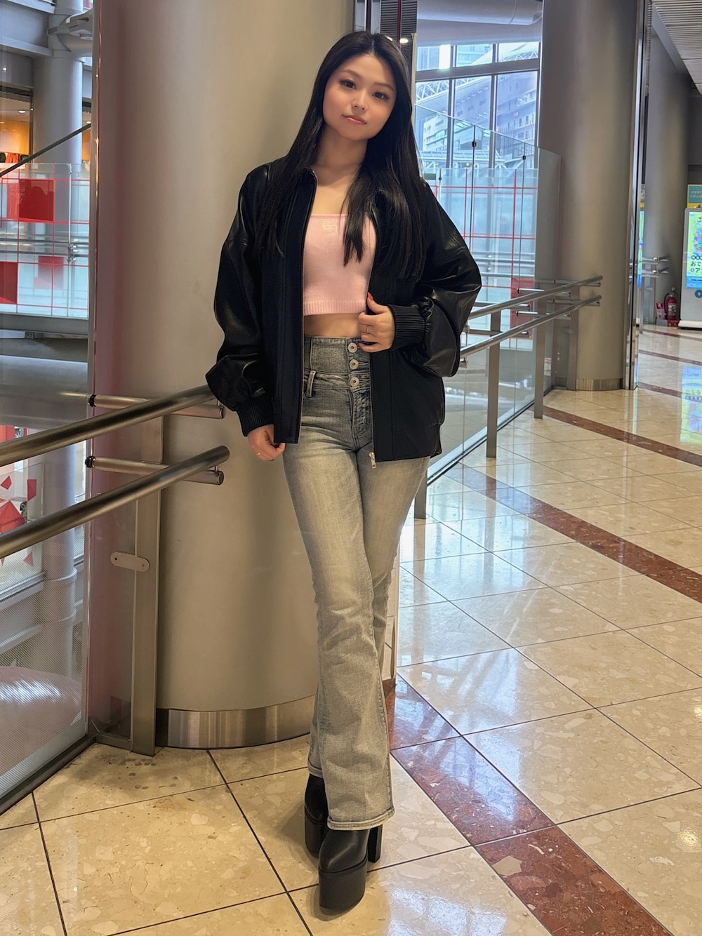 ブラック系のブルゾン、ブルー系のデニムパンツ、ブラック系のブーツを着用したレディースの春コーディネートの1枚目の写真