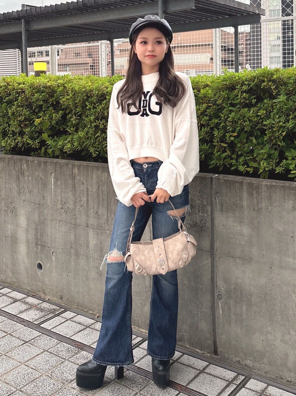 ホワイト系のニット/セーター、ブルー系のデニムパンツ、ベージュ系のショルダーバッグを着用したレディースの秋コーディネートの1枚目の写真