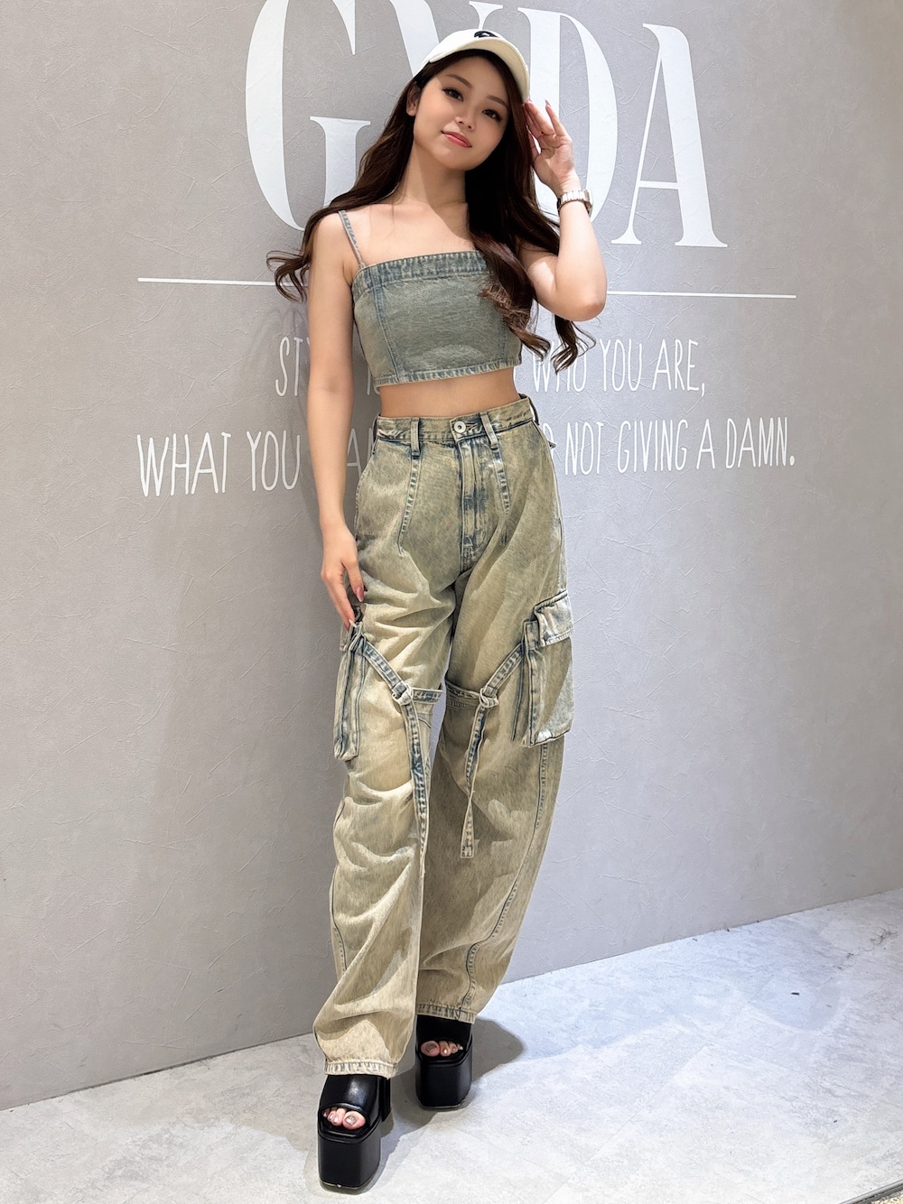 ブルー系のキャミソール、ブルー系のデニムパンツ、ブラック系のサンダルを着用したレディースの夏コーディネートの1枚目の写真