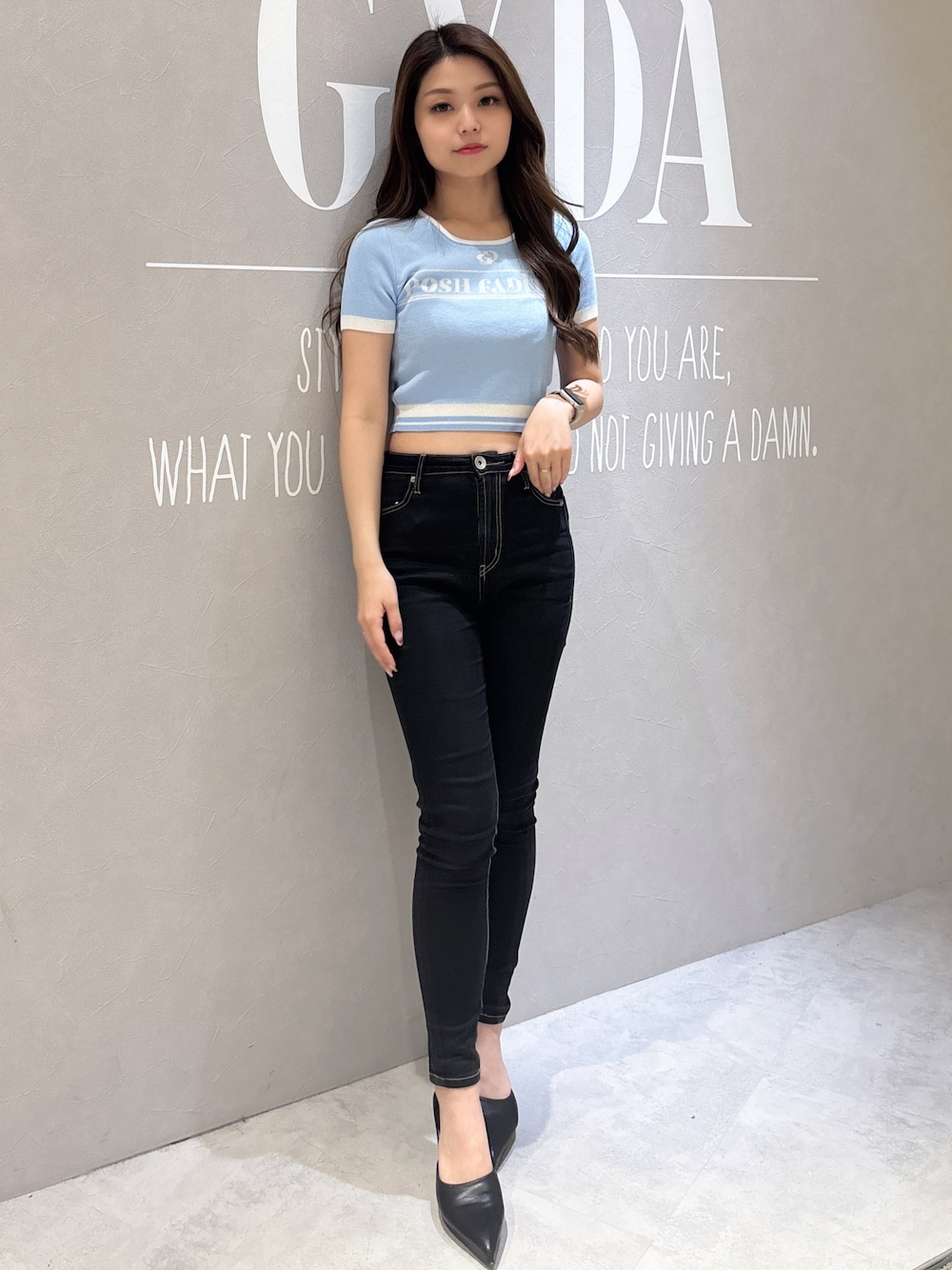 ブルー系のニット/セーター、ブラック系のデニムパンツ、ホワイト系のパンプスを着用したレディースの春コーディネートの1枚目の写真