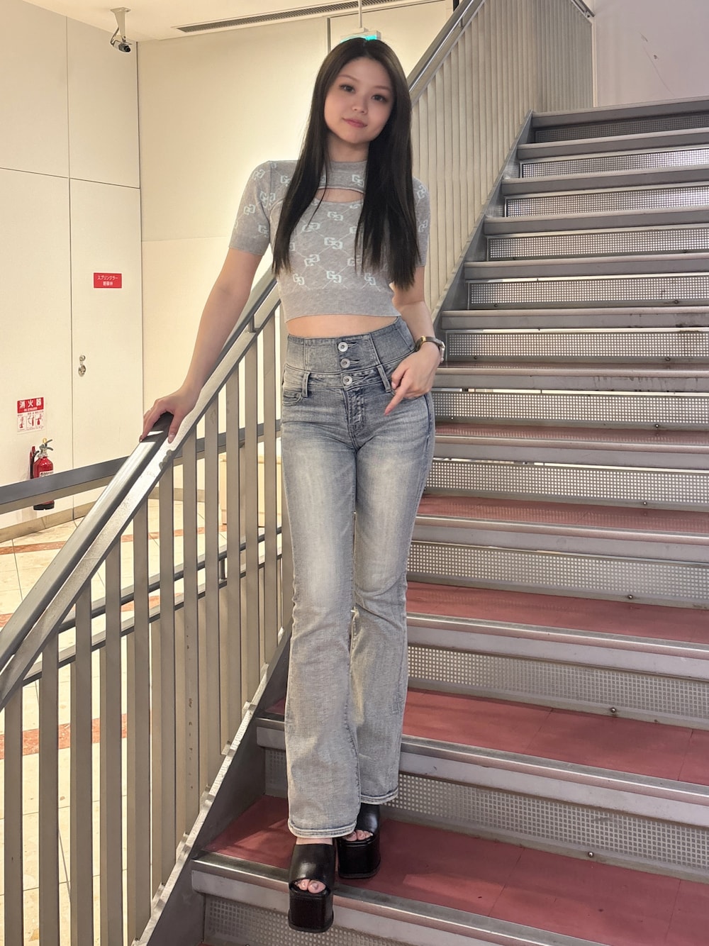 グレー系のニット/セーター、ブルー系のデニムパンツ、ブラック系のサンダルを着用したレディースの春コーディネートの1枚目の写真