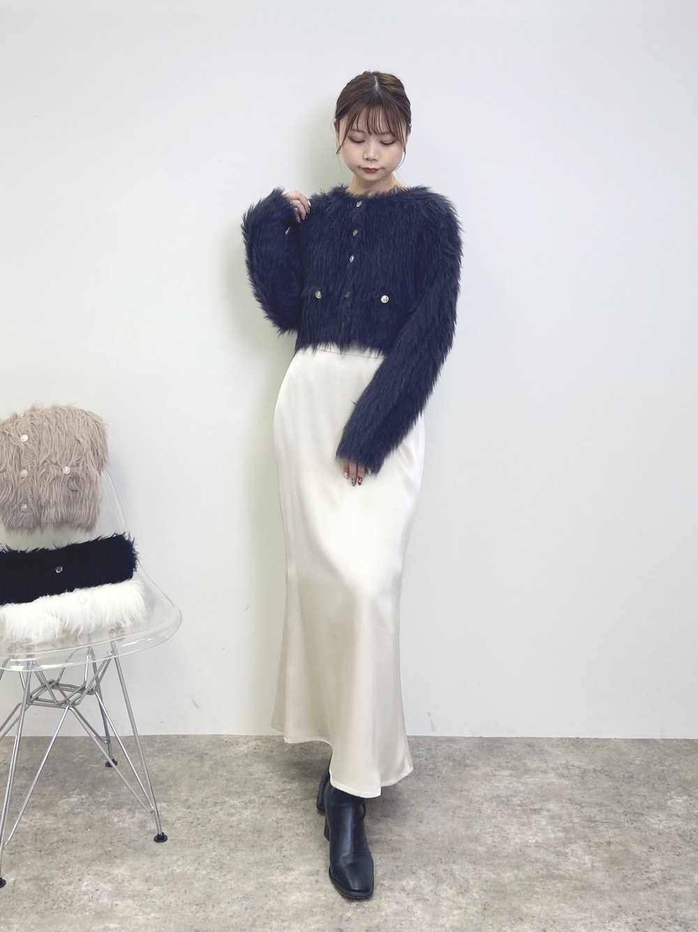 ホワイト系のスカート、グレー系のカーディガン/ボレロを着用したレディースの秋コーディネートの1枚目の写真