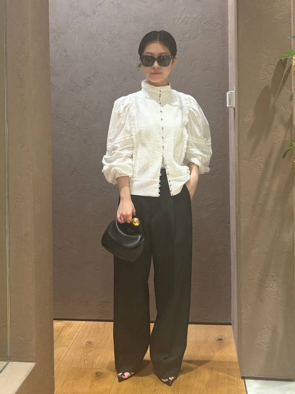 グレー系のスラックス、ホワイト系のシャツ/ブラウスを着用したレディースの春コーディネートの1枚目の写真