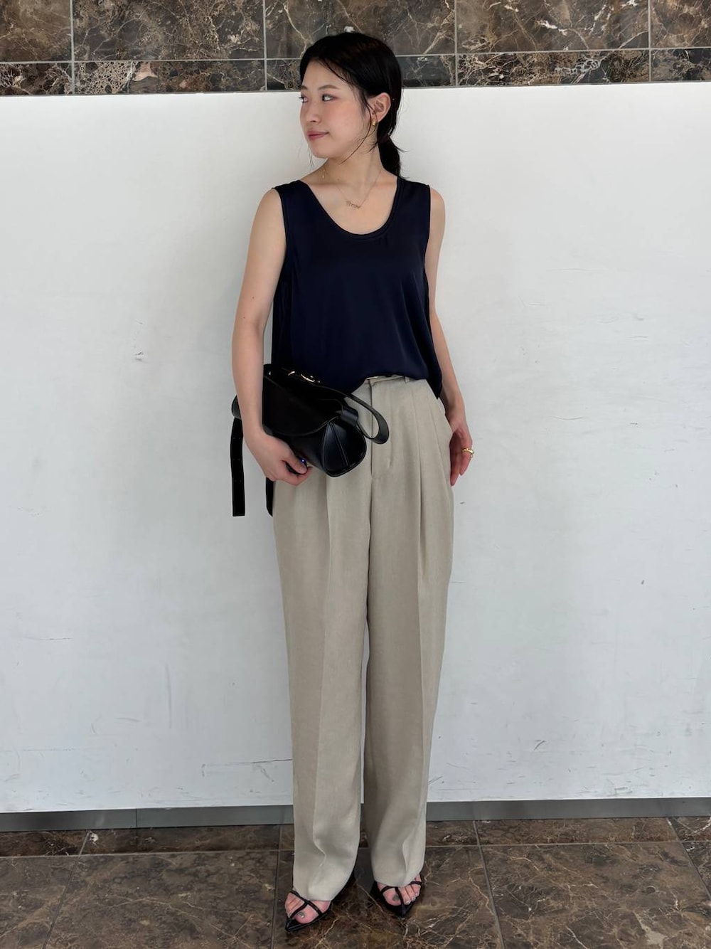 ブルー系のシャツ/ブラウス、ベージュ系のスラックスを着用したレディースの夏コーディネートの1枚目の写真