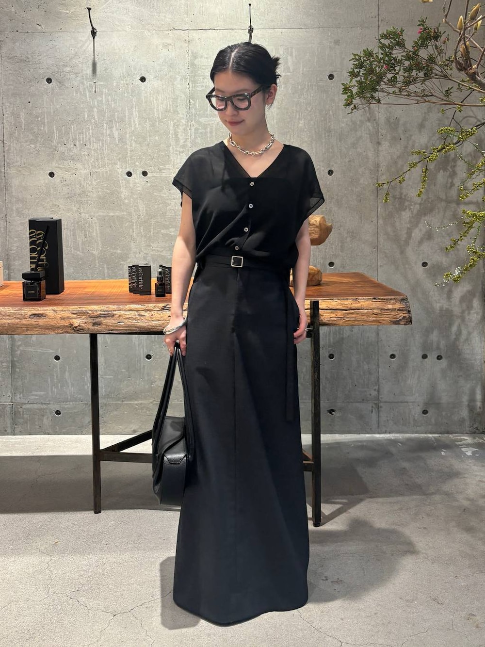 ブラック系のカーディガン/ボレロ、グレー系のスカートを着用したレディースの夏コーディネートの1枚目の写真