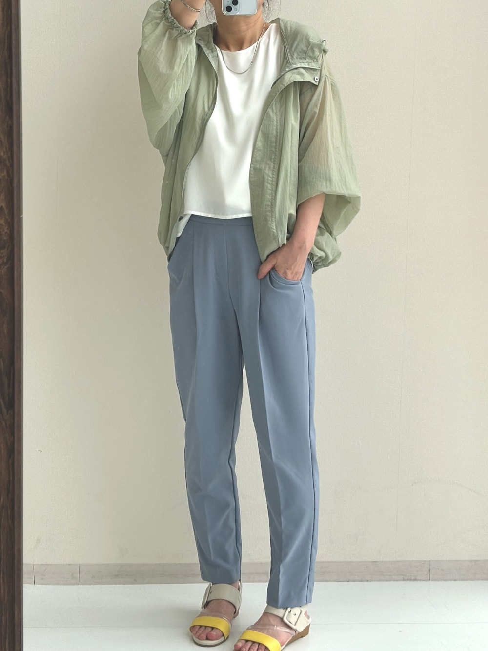 ホワイト系のシャツ/ブラウス、グリーン系のブルゾン、ブルー系のスラックスを着用したレディースの春コーディネートの1枚目の写真