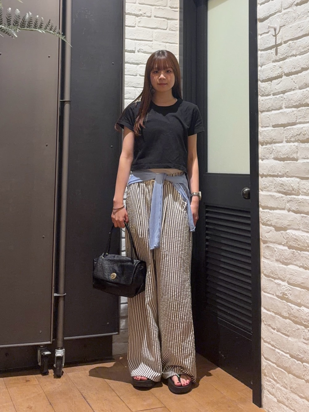 ブラック系のTシャツ/カットソー、ブラック系のハンドバッグ、ブルー系のその他パンツを着用したレディースの夏コーディネートの1枚目の写真