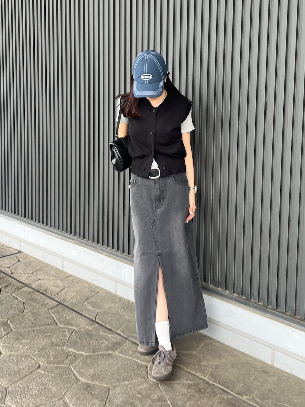 ブラック系のベスト、グレー系のTシャツ/カットソー、ブラック系のハンドバッグを着用したレディースの春コーディネートの1枚目の写真