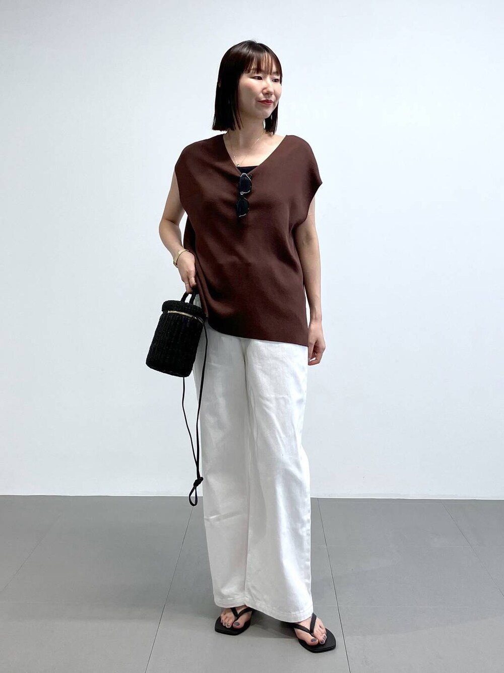 ブラック系のショルダーバッグ、ホワイト系のデニムパンツ、ブラック系のサンダルを着用したレディースの夏コーディネートの1枚目の写真