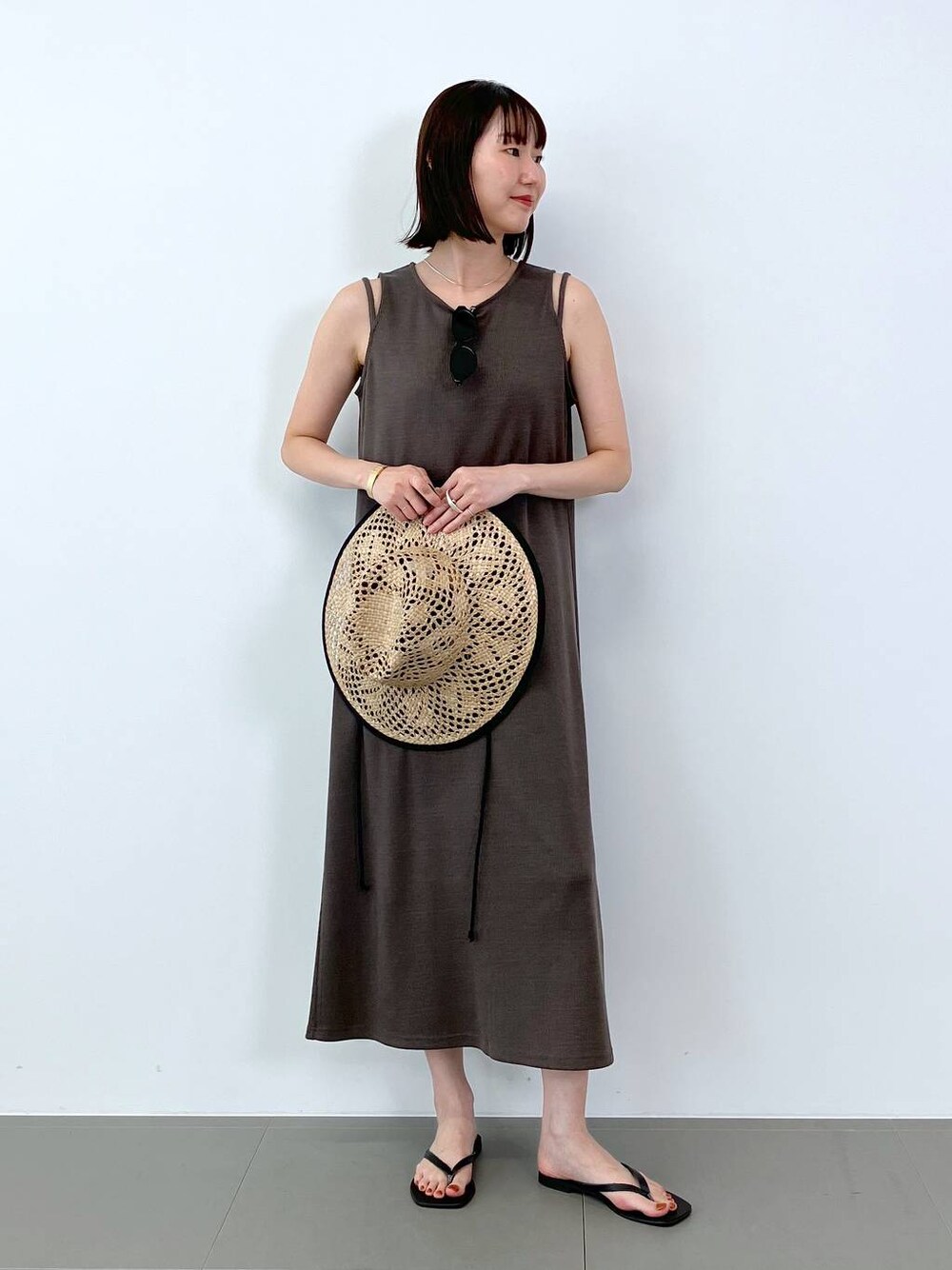 ブラック系のサンダル、ブラウン系のワンピース、ベージュ系のハットを着用したレディースの夏コーディネートの1枚目の写真