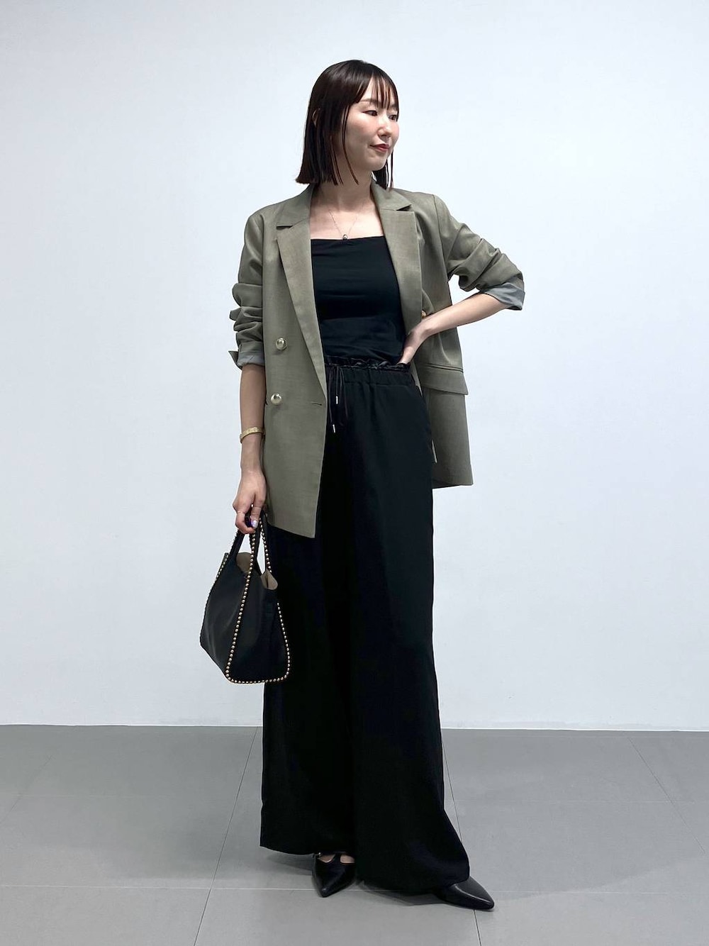 ブラック系のトートバッグ、グリーン系のテーラードジャケット、ブラック系のその他パンツを着用したレディースの夏コーディネートの1枚目の写真