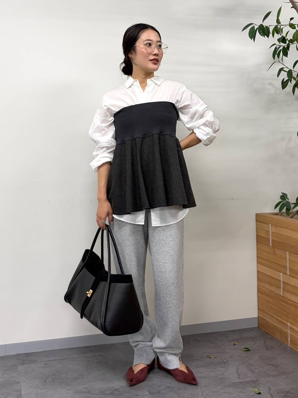 レッド系のパンプス、グレー系のスウェットパンツ、ブラック系のボストンバッグを着用したレディースの秋コーディネートの1枚目の写真