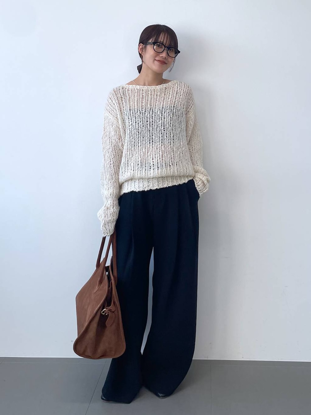 ホワイト系のニット/セーター、ブラック系のその他パンツ、ブラウン系のボストンバッグを着用したレディースの夏コーディネートの1枚目の写真