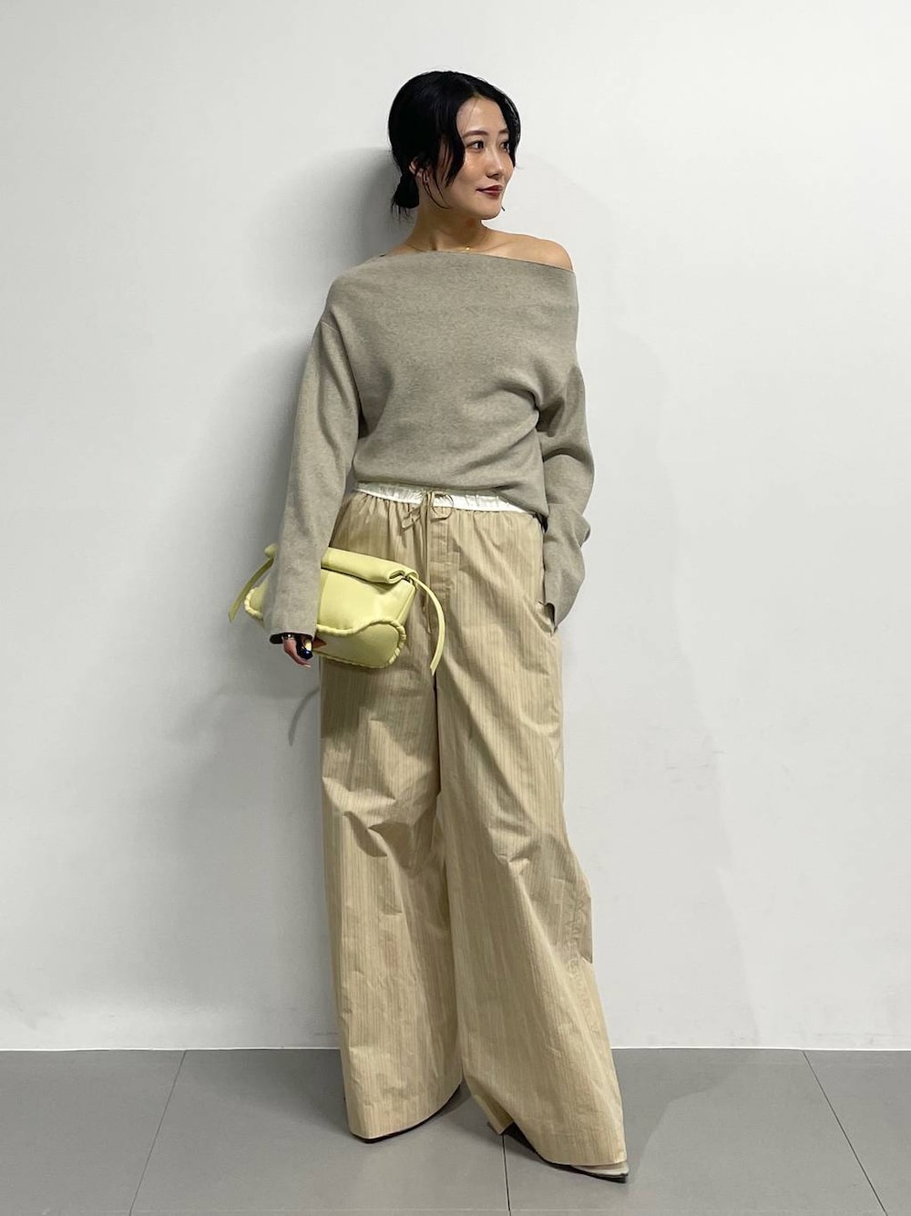 ベージュ系のパンプス、イエロー系のハンドバッグ、ベージュ系のその他パンツを着用したレディースの冬コーディネートの1枚目の写真