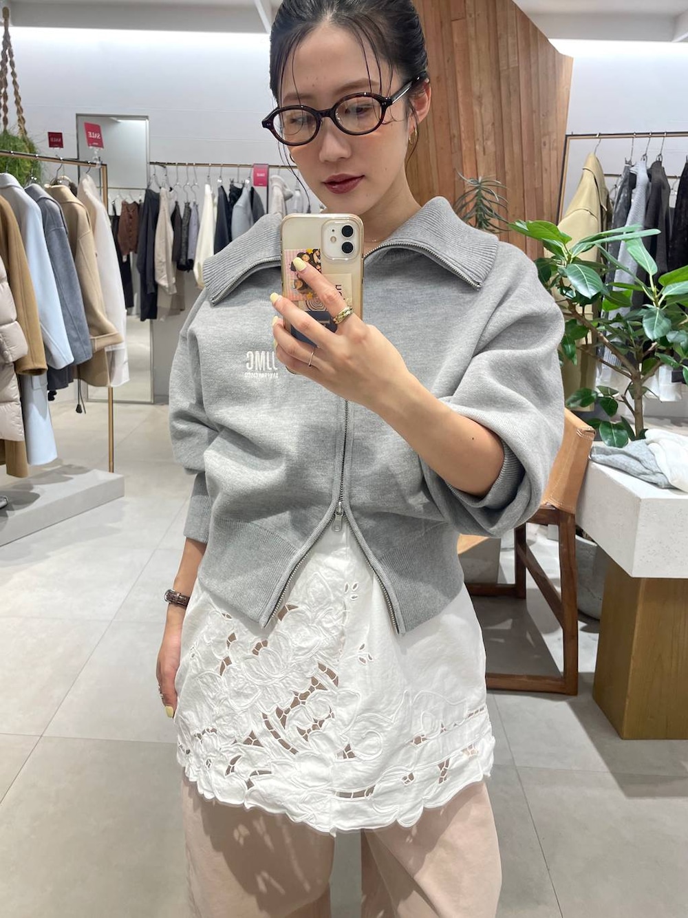 ピンク系のデニムパンツ、ベージュ系のパンプス、グレー系のスウェットを着用したレディースの冬コーディネートの1枚目の写真