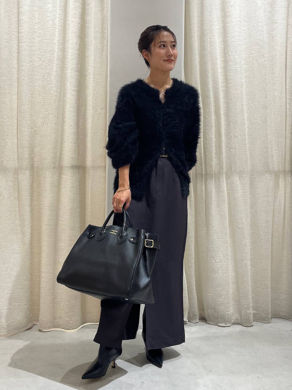 ブラック系のカーディガン/ボレロ、グレー系のスカート、ブラック系のハンドバッグを着用したレディースの秋コーディネートの1枚目の写真