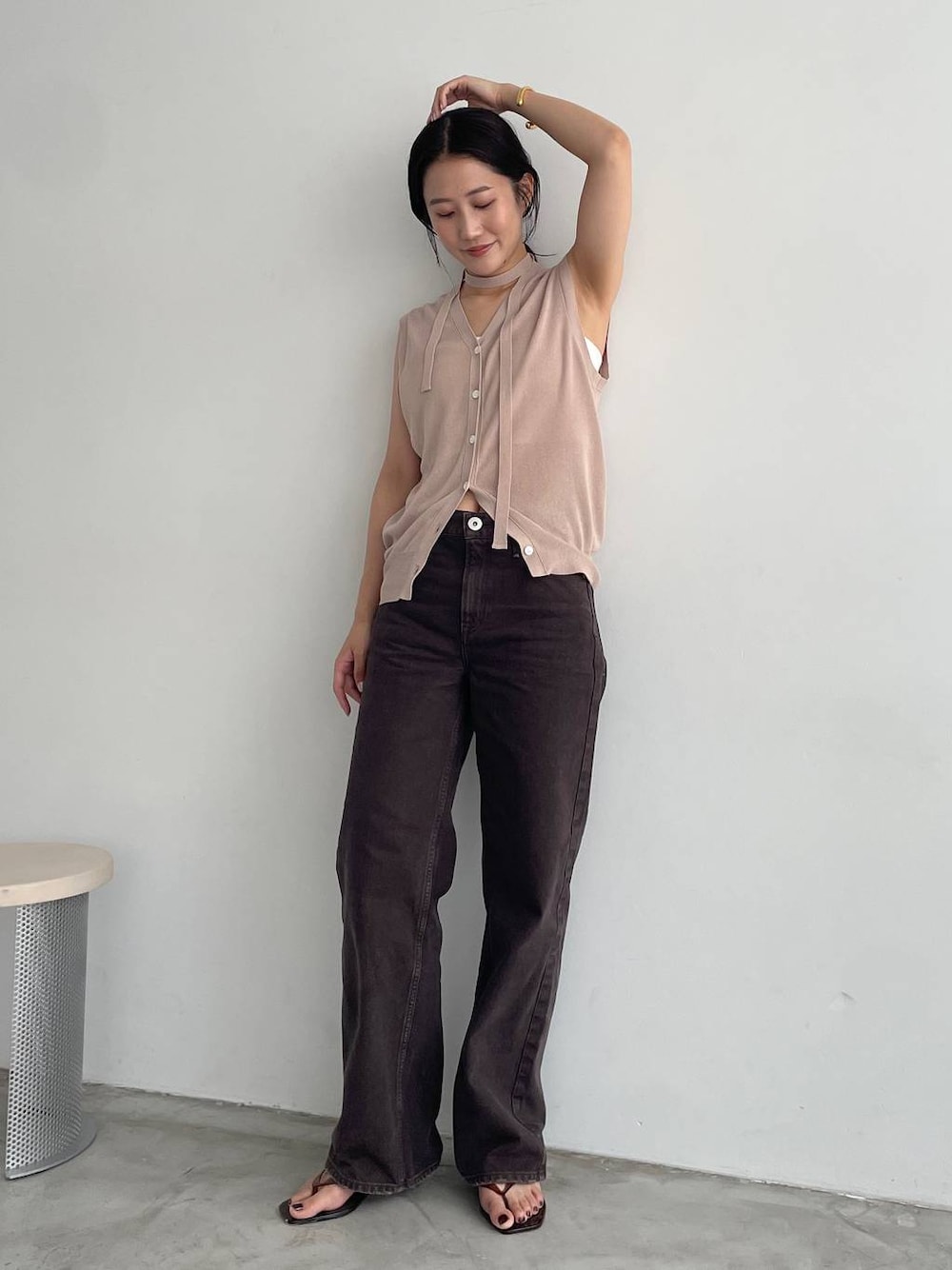 ホワイト系のキャミソール、ブラウン系のデニムパンツ、ベージュ系のニット/セーターを着用したレディースの夏コーディネートの1枚目の写真