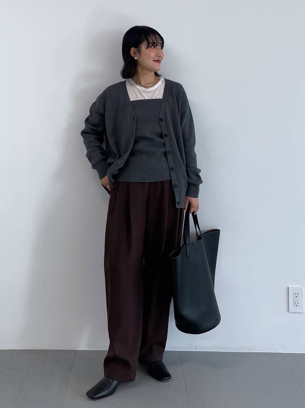 ブラック系のトートバッグ、ブラウン系のその他パンツ、グレー系のカーディガン/ボレロを着用したレディースの冬コーディネートの1枚目の写真