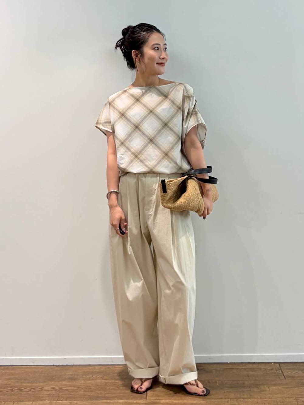 ベージュ系のシャツ/ブラウス、ベージュ系のかごバッグ、ブラウン系のサンダルを着用したレディースの夏コーディネートの1枚目の写真