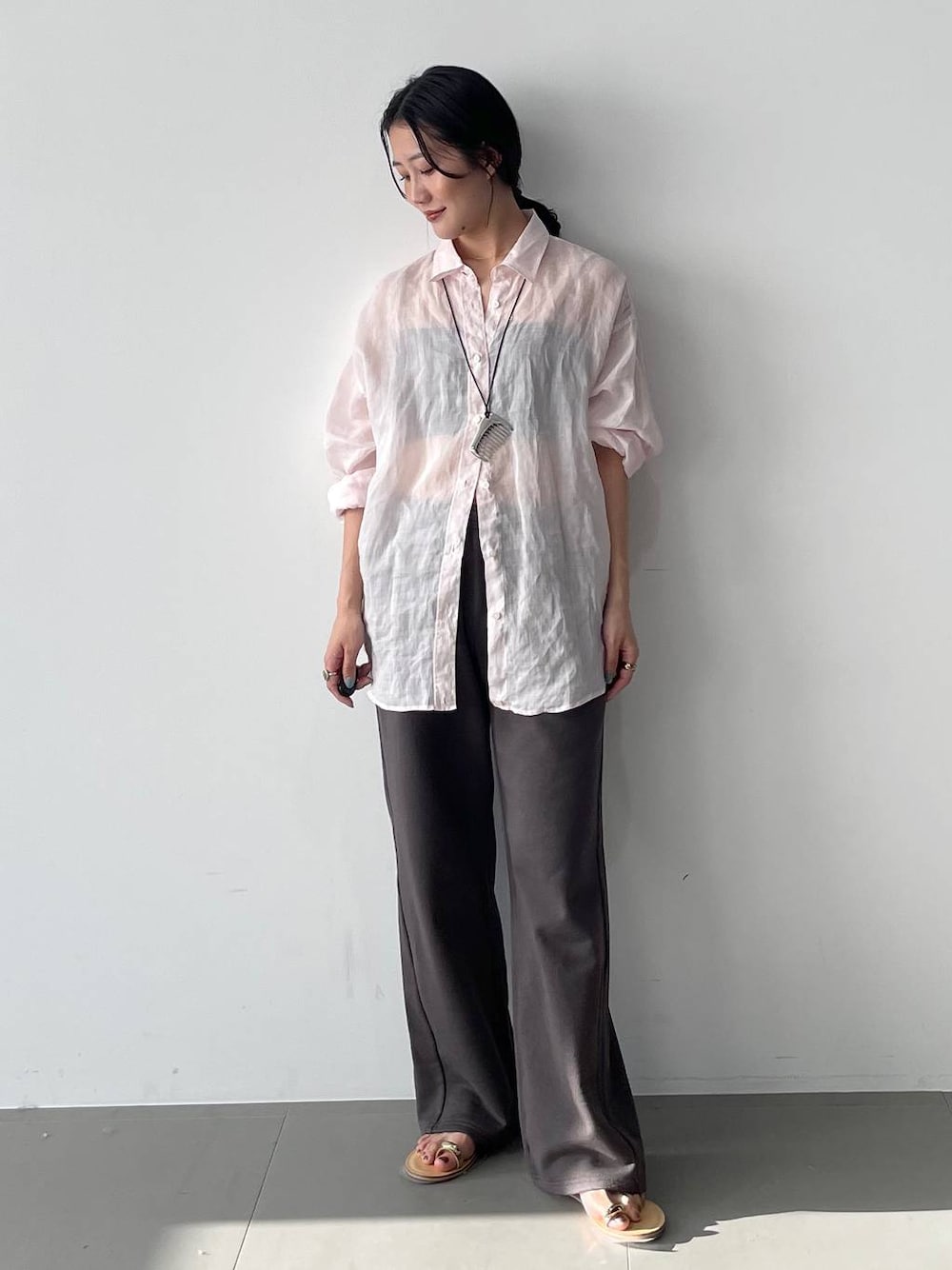 ピンク系のシャツ/ブラウス、グレー系のスウェットパンツを着用したレディースの春コーディネートの1枚目の写真