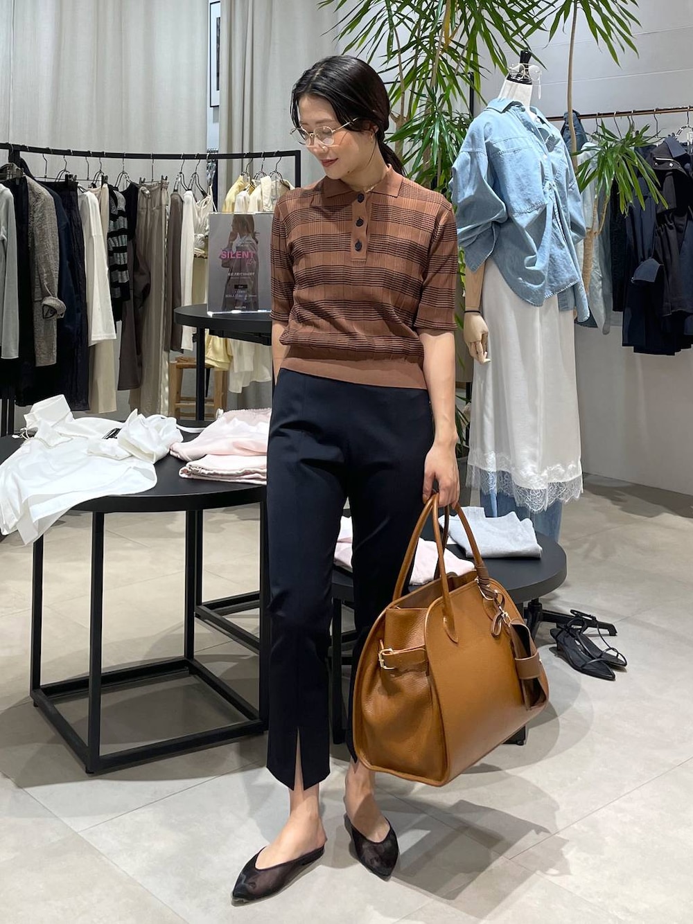 ブラック系のパンプス、ブラウン系のボストンバッグ、ブラック系のその他パンツを着用したレディースの春コーディネートの1枚目の写真