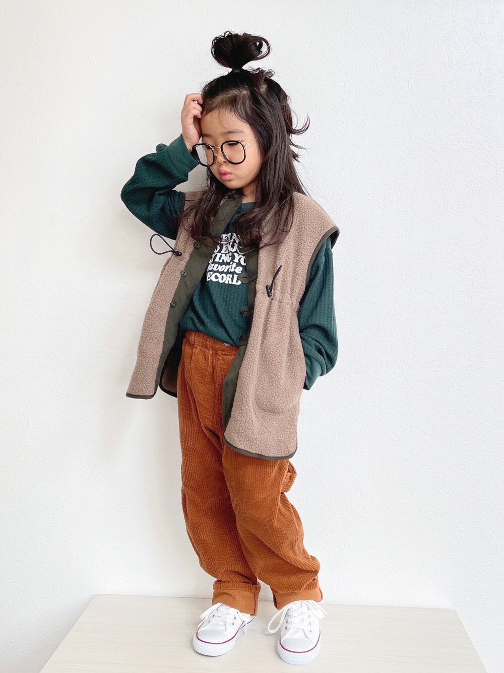 グリーン系のTシャツ/カットソー、ブラウン系のベスト、イエロー系のその他パンツを着用したキッズの秋コーディネートの1枚目の写真