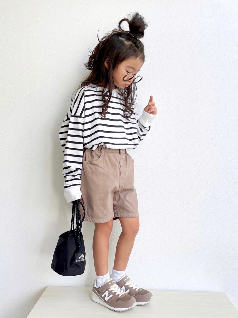 ブラック系のTシャツ/カットソー、ブラウン系のデニムパンツ、ブラック系のトートバッグを着用したキッズの秋コーディネートの1枚目の写真