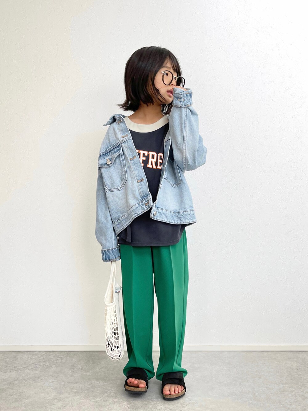 グリーン系のスラックス、グレー系のTシャツ/カットソー、ブルー系のデニムジャケットを着用したキッズの春コーディネートの1枚目の写真