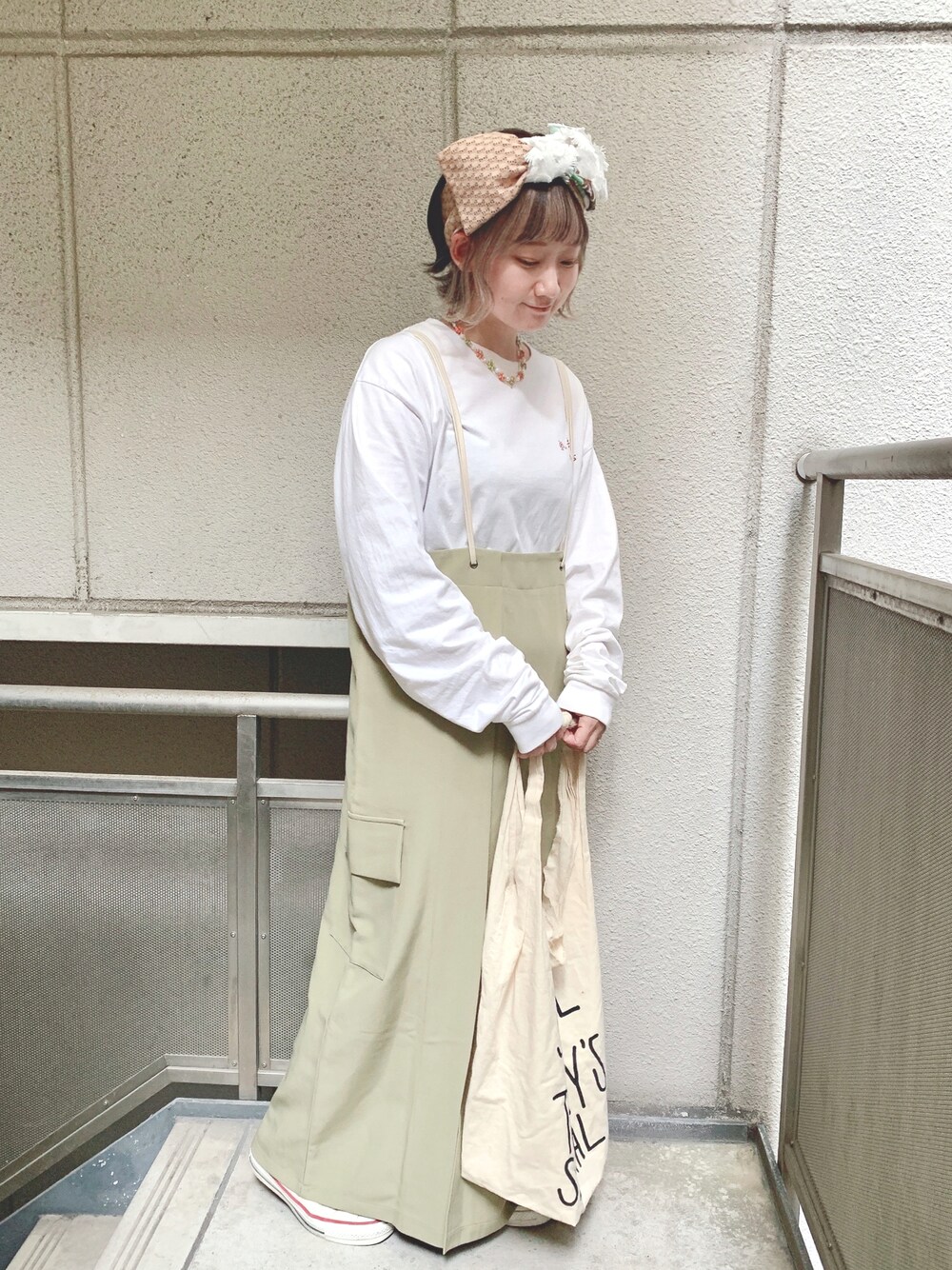 ホワイト系のTシャツ/カットソー、グリーン系のジャンパースカート、ホワイト系のエコバッグ/サブバッグを着用したレディースの春コーディネートの1枚目の写真