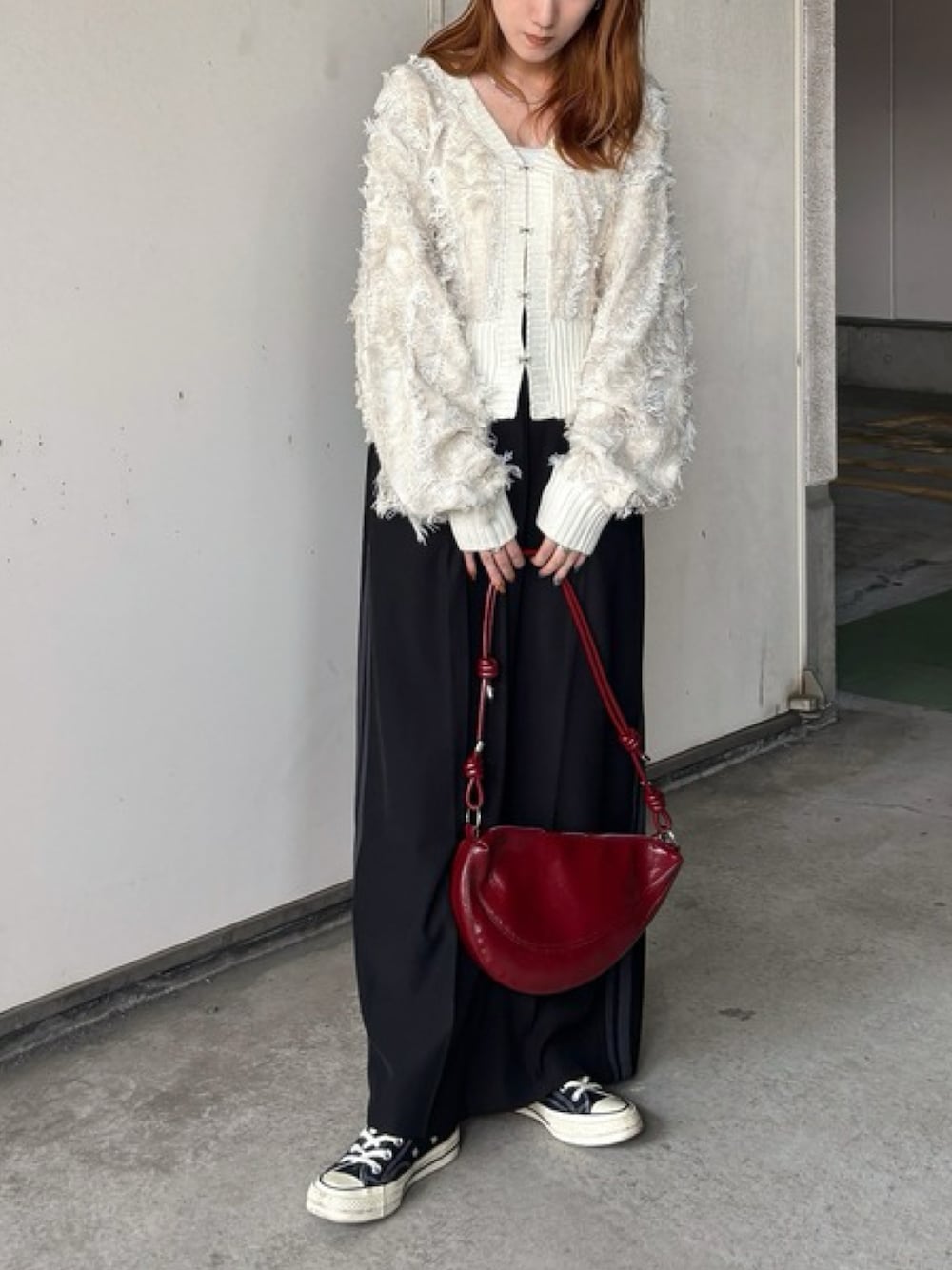 ホワイト系のニット/セーター、レッド系のハンドバッグ、ブラック系のスカートを着用したレディースの秋コーディネートの1枚目の写真
