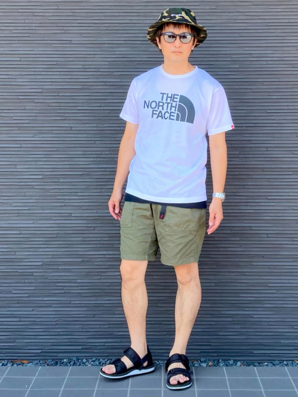 ホワイト系のTシャツ/カットソー、ブラック系のTシャツ/カットソー、グリーン系のその他パンツを着用したメンズの夏コーディネートの1枚目の写真