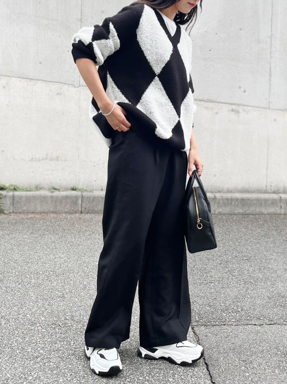 ブラック系のショルダーバッグ、ブラック系のスニーカーを着用したレディースの秋コーディネートの1枚目の写真