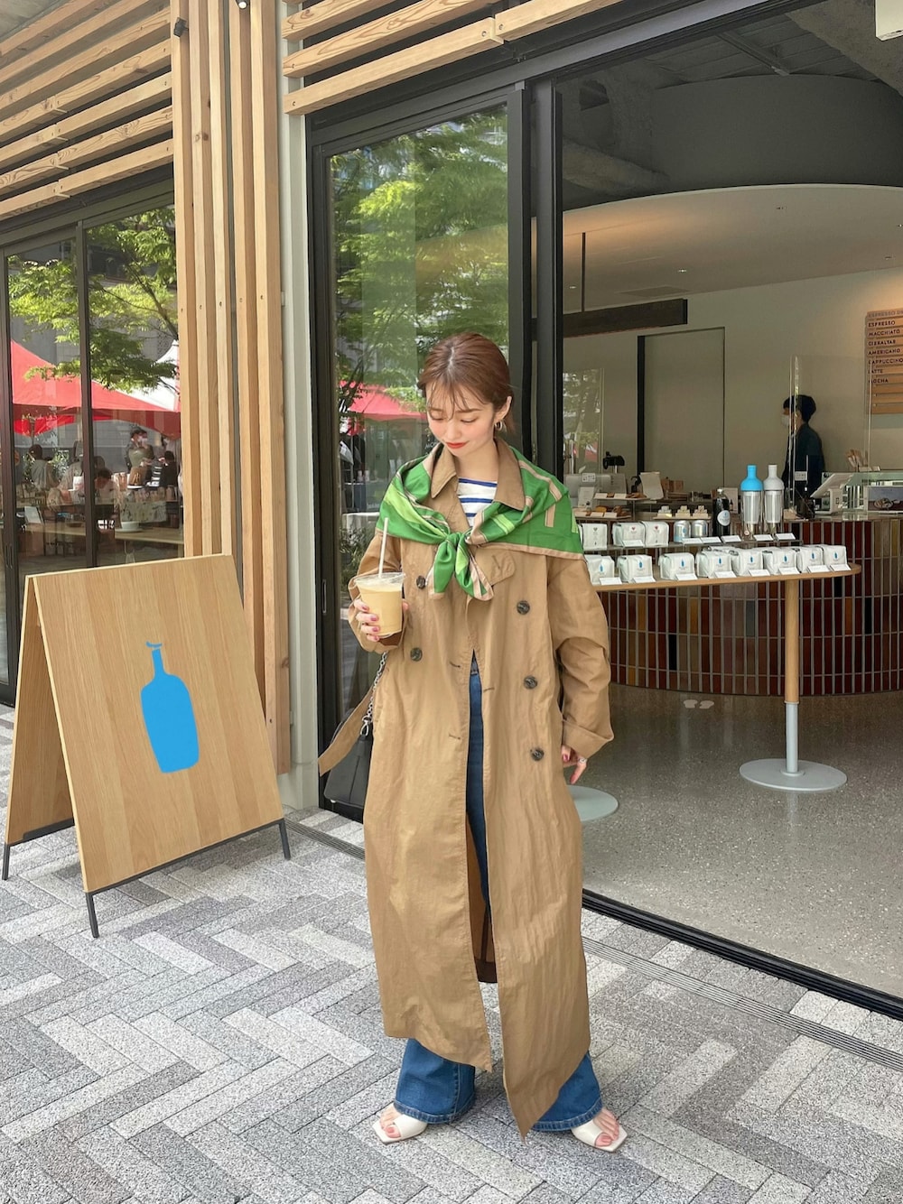 ホワイト系のサンダル、ホワイト系のTシャツ/カットソー、ベージュ系のトレンチコートを着用したレディースの春コーディネートの1枚目の写真