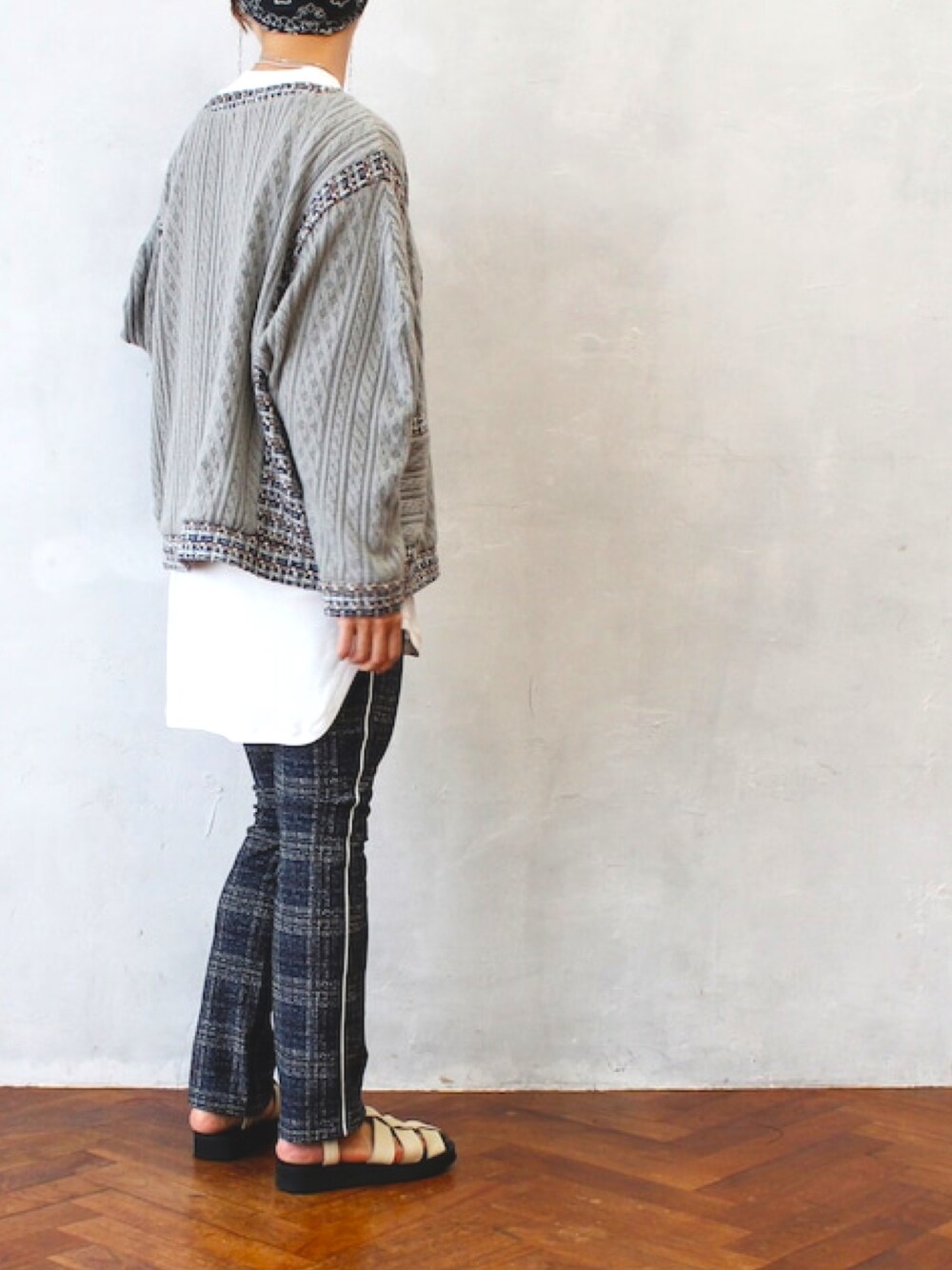 グレー系のカーディガン/ボレロ、ホワイト系のTシャツ/カットソー、ブルー系のスラックスを着用したレディースの秋コーディネートの1枚目の写真