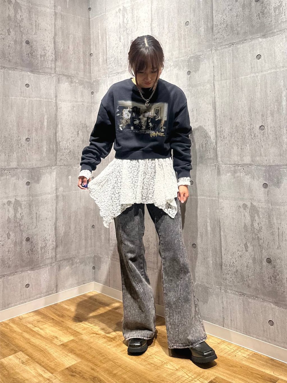 グレー系のスウェット、ブラック系のデニムパンツ、ホワイト系のチュニックを着用したレディースの秋コーディネートの1枚目の写真