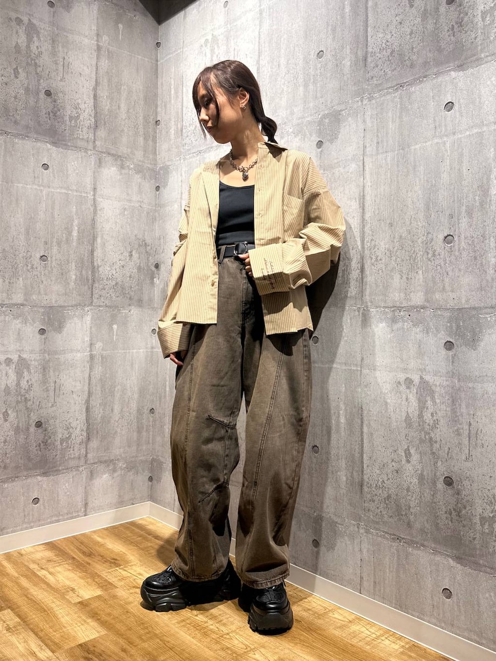 ブラウン系のデニムパンツ、ブラック系のスニーカー、ベージュ系のシャツ/ブラウスを着用したレディースの秋コーディネートの1枚目の写真