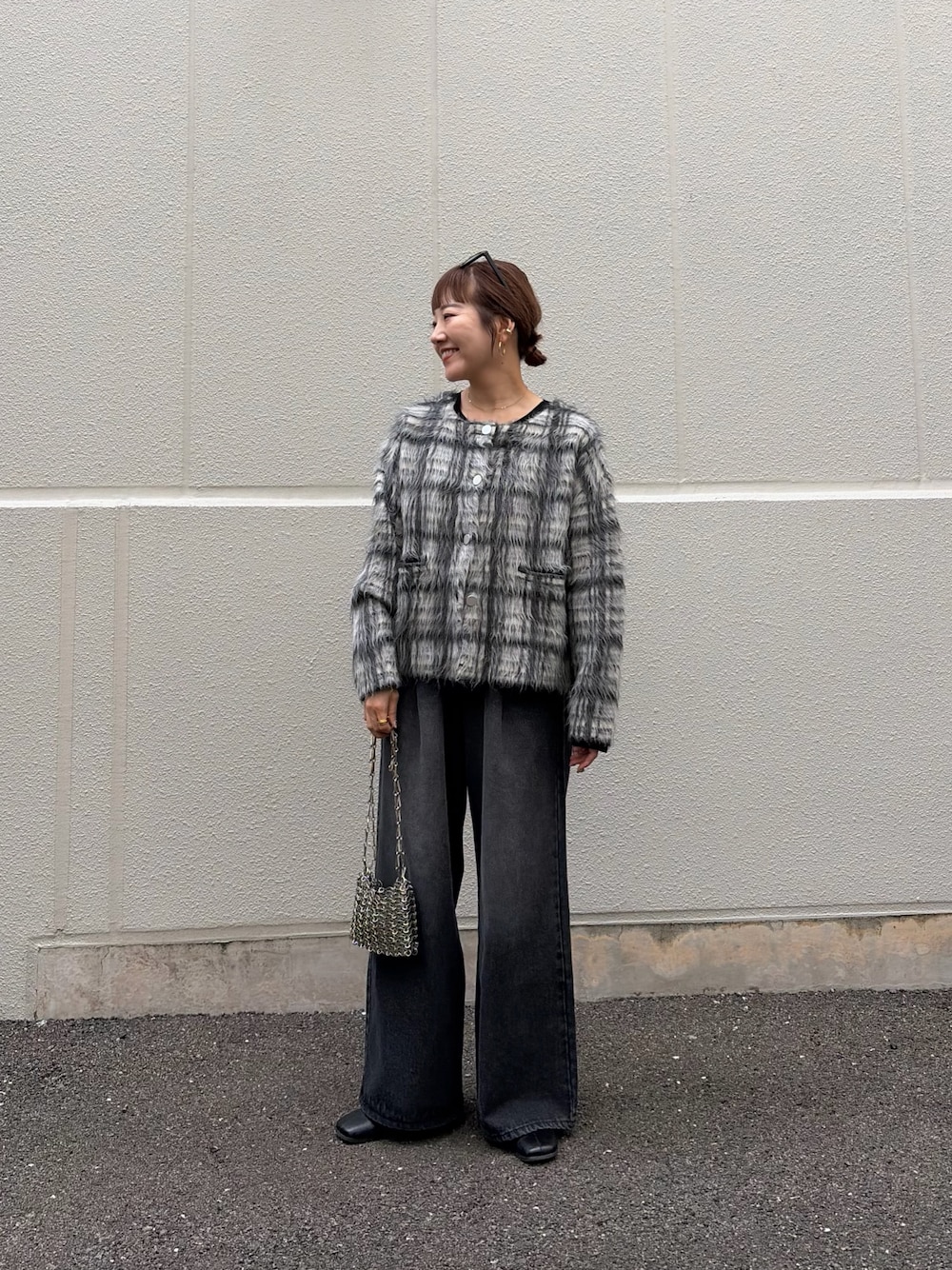ブラック系のTシャツ/カットソー、ホワイト系のニット/セーター、ブラック系のデニムパンツを着用したレディースの秋コーディネートの1枚目の写真