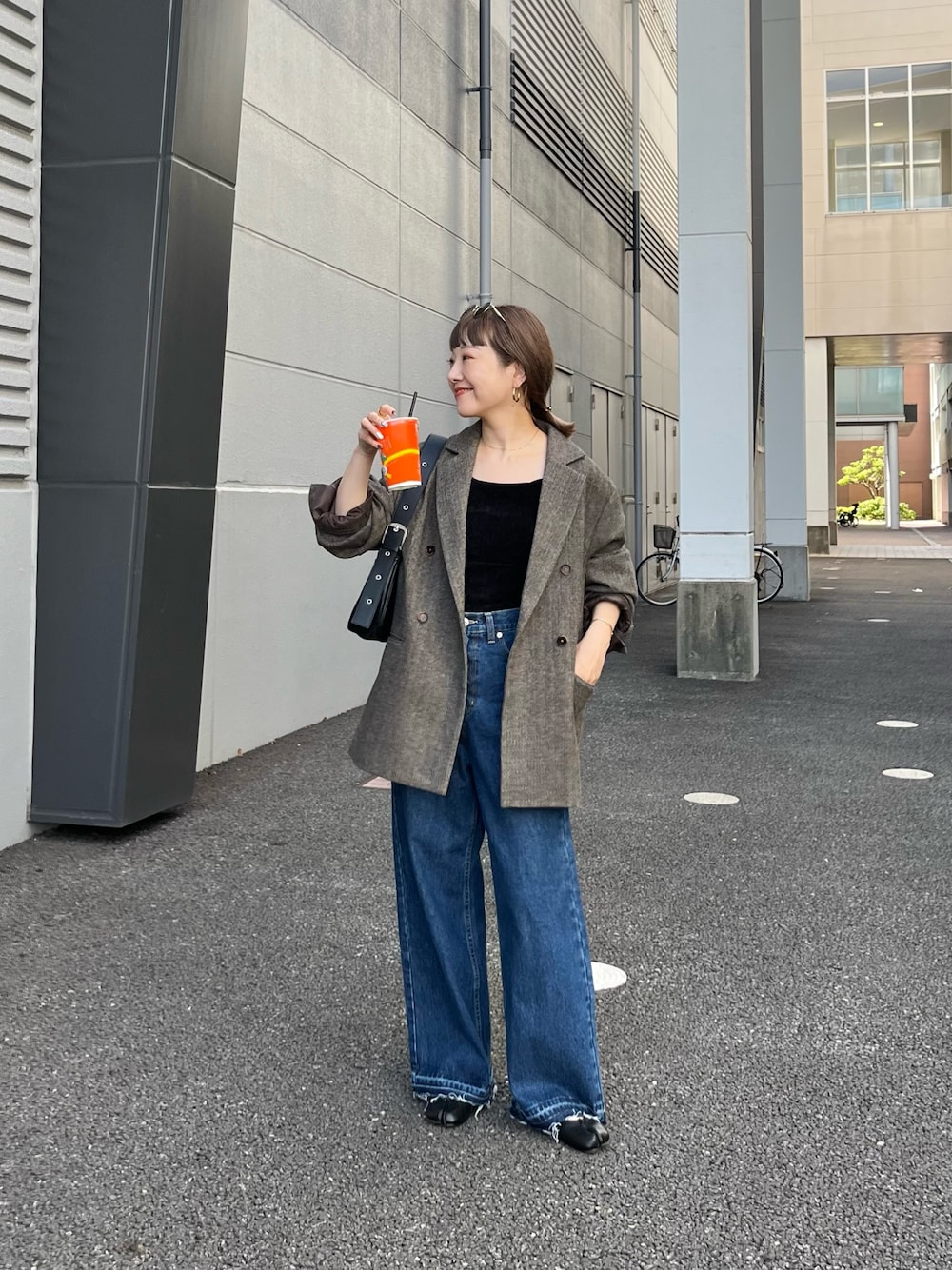 ブラウン系のテーラードジャケット、ブルー系のデニムパンツ、ブラック系のトートバッグを着用したレディースの夏コーディネートの1枚目の写真