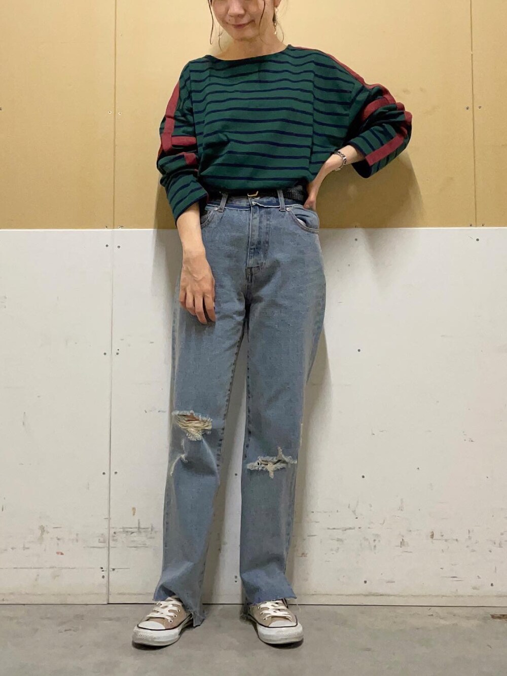 ブルー系のデニムパンツ、グリーン系のTシャツ/カットソーを着用したレディースの秋コーディネートの1枚目の写真