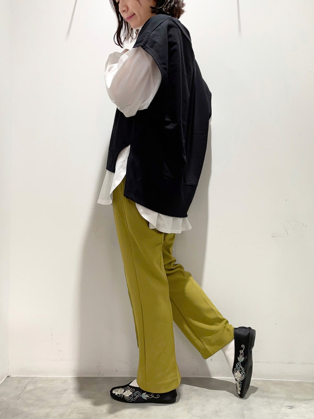 イエロー系のその他パンツ、ブラック系のベスト、ホワイト系のTシャツ/カットソーを着用したレディースの秋コーディネートの1枚目の写真