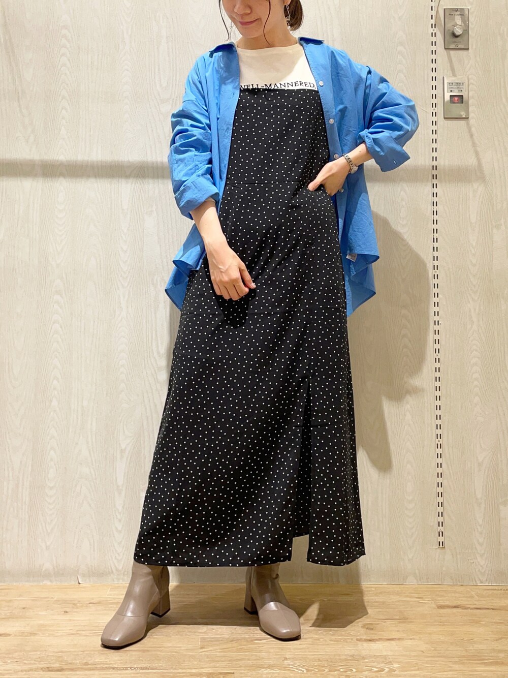 ブラック系のワンピース、ベージュ系のブーツ、ブルー系のシャツ/ブラウスを着用したレディースの秋コーディネートの1枚目の写真