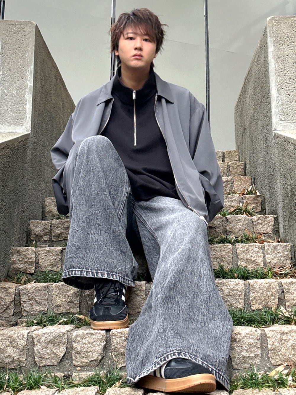 ブラック系のデニムパンツ、ブラック系のTシャツ/カットソー、グレー系のブルゾンを着用したメンズの秋コーディネートの1枚目の写真