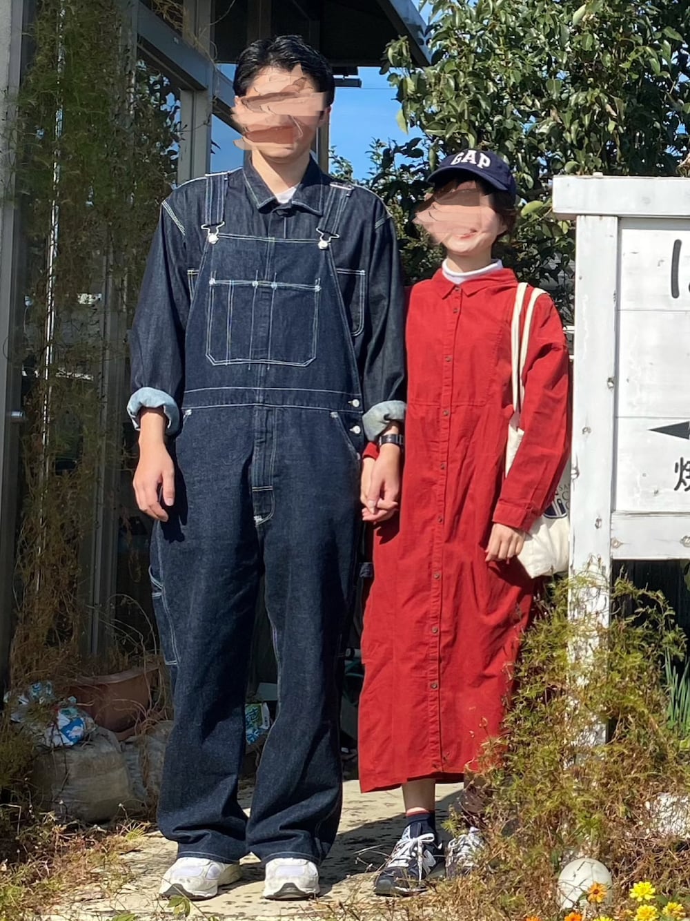 ブルー系のサロペット/オーバーオール、ブルー系のデニムジャケット、レッド系のワンピースを着用したレディースの秋コーディネートの1枚目の写真